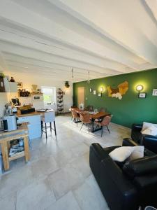 a living room with a couch and a table at Ferme les Chapelles Utah Beach in Angoville-au-Plain