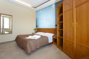 a bedroom with a bed and a wooden cabinet at Hotel President in Alba Adriatica