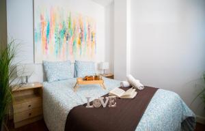 1 dormitorio con 1 cama y 1 mesa con libros en Elite Premium Hideaway with FREE Parking - Malaga, en Málaga