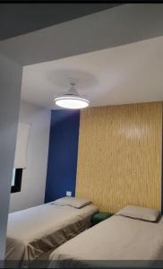 a room with two beds and a blue wall at Casa Paradiso Salta in Salta