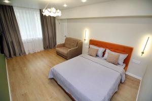 a hotel room with a bed and a chair at Center Almaty in Almaty