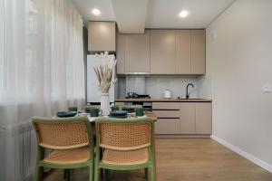 a kitchen with a table and chairs and a kitchen with white cabinets at Center Almaty in Almaty