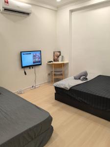 a bedroom with two beds and a flat screen tv at Hiker haven homestay PJ Gasing in Petaling Jaya