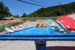 una piscina con tumbonas y sombrillas en Pavlovica konaci, en Kotraža 30 fotos más