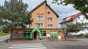 a building with a green arch in front of it at Willa BIM in Rewal