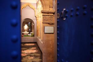 un pasillo en una casa con una puerta azul en L'Alcazar en Rabat