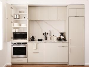 a white kitchen with white cabinets and appliances at Mint House Washington Dc Downtown By Kasa in Washington, D.C.