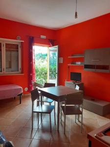 a dining room with red walls and a table and chairs at B & B Residence L'Ancora in Villapiana