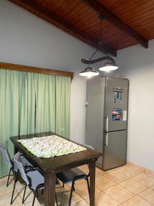Una cocina con una mesa con sillas y un refrigerador. en Casa Atardecer, en Eldorado