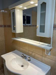 Un baño con un lavabo blanco y un espejo. en Casa Atardecer, en Eldorado