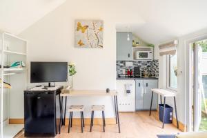 a small kitchen with a desk with a computer on it at Charming Private Guest House in Enfield