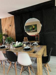 a dining room with a table with chairs and a mirror at Ma maison peruvienne- departamento muy cerca aéropuerto in Lima