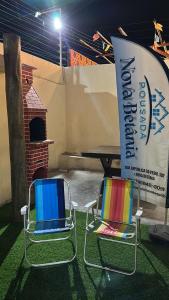 two chairs sitting next to a table with a sign at Pousada Nova Betânia in Mossoró