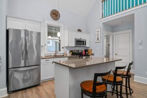 a kitchen with white cabinets and a stainless steel refrigerator at The Jack Pine - 50 Hollow in Cherry Valley