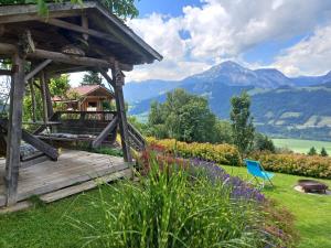 a wooden deck in a garden with a view of mountains at Panoramahof Gupf in Gröbming