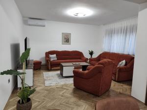 a living room with two couches and a table at Apartman Lidija in Bihać