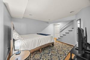 a bedroom with a bed and a tv and stairs at Spacious 3BR Home 5 Mins to Airport and Downtown in Columbus