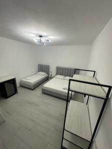 Habitación blanca con 2 camas y mesa en Gold Rooms II, en Sarandë