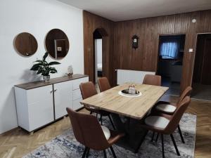 a dining room with a wooden table and chairs at Apartman Lidija in Bihać