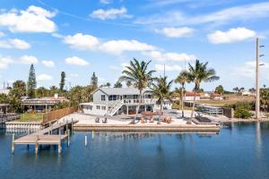 a house on the water with a dock at The Banana River Resort in Cocoa Beach