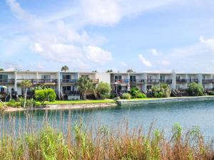 a row of apartment buildings next to a body of water at Coconuts Beach House in Pensacola Beach