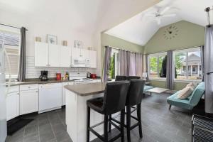a kitchen with white cabinets and a table and chairs at The King Eider - 24 Meadow View in Cherry Valley