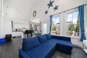 a living room with a blue couch and stars on the wall at The King Eider - 24 Meadow View in Cherry Valley