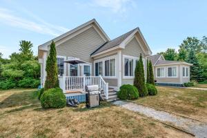 a house with a front porch with an umbrella at The King Eider - 24 Meadow View in Cherry Valley