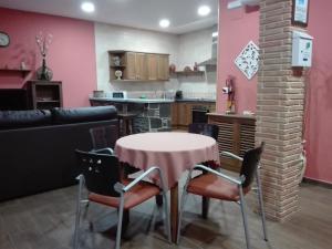 kuchnia i salon ze stołem i krzesłami w obiekcie Casa Rural Casa Queta w mieście Palomero