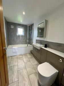 Un baño con inodoro, lavabo y bañera. en Seaside Getaway with Balcony & Ocean Views - Westward Ho!, en Westward Ho