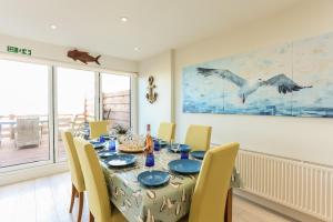a dining room with a table and chairs and a large window at The Beach House in Chichester