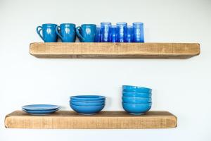 a row of blue bowls on a wooden shelf at The Beach House in Chichester +49 photos