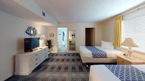 ein Hotelzimmer mit zwei Betten und einem Flachbildfernseher in der Unterkunft Las Olas Beach Club of Satellite Beach in Satellite Beach + 8 Fotos