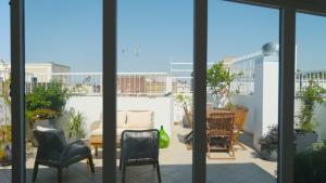 einen Balkon mit Blick auf eine Terrasse mit Stühlen und einem Tisch in der Unterkunft Hecate in Mesagne