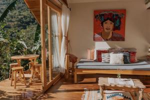 a bedroom with a bed with a painting on the wall at Casa Awänímä - Ecological Wellness Sanctuary in Tzununá