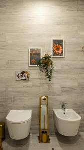 a bathroom with a white toilet and a sink at Aurora do Furadouro in Ovar