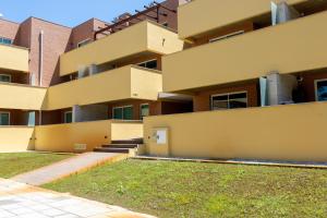 an apartment building with a lawn in front of it at Aurora do Furadouro in Ovar