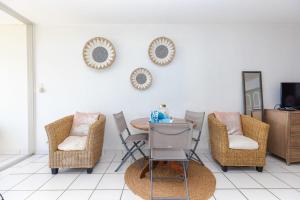 Cette chambre dispose de chaises, d'une table et d'une télévision. dans l'établissement Jolie Studio Mont Vernon Escape, à Cul de Sac