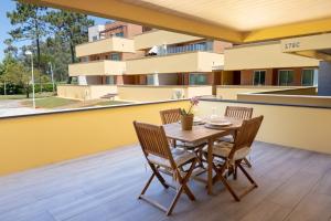a table and chairs on the balcony of a building at Aurora do Furadouro in Ovar