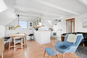 een keuken en woonkamer met een tafel en stoelen bij 2250-Ringkobing-Vestklitvej-25 in Klegod