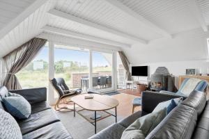 een woonkamer met een bank en een tafel bij 2250-Ringkobing-Vestklitvej-25 in Klegod