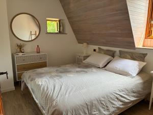 a bedroom with a large bed and a mirror at Gîte de charme La Pradelle in Prats-du-Périgord +23 photos