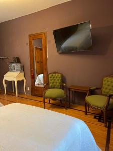 a room with two chairs and a bed and a mirror at Habitación Martinique Bed&Breakfast 4 personas en la Condesa in Mexico City