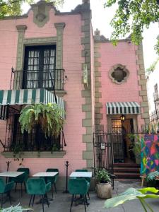 a pink building with tables and chairs in front of it at Habitación Martinique Bed&Breakfast 4 personas en la Condesa in Mexico City