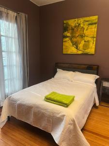 a bed with a green towel on top of it at Habitación Martinique Bed&Breakfast 4 personas en la Condesa in Mexico City