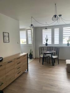 a living room with a table and chairs and windows at Apartament Max in Busko-Zdrój