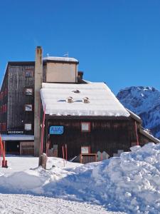 ein Gebäude mit Schnee auf dem Dach in der Unterkunft La Tana della Volpe, Falcade - BL in Falcade