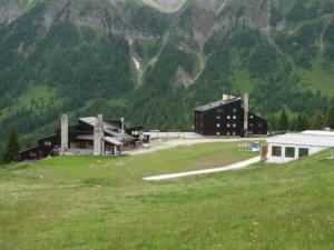 ein großes Gebäude auf einem Feld mit einem Berg in der Unterkunft La Tana della Volpe, Falcade - BL in Falcade