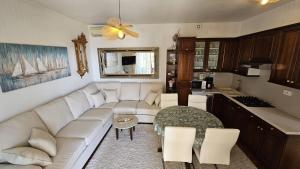 a living room with a white couch and a kitchen at Apartments Cavar in Rab