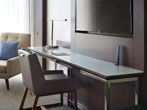 a desk in a hotel room with a chair and a television at Marriott at the University of Dayton in Dayton